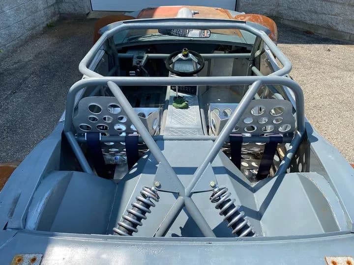 The owner's photo of the Mustang's stripped interior: roll cage, perforated seats and coilovers
