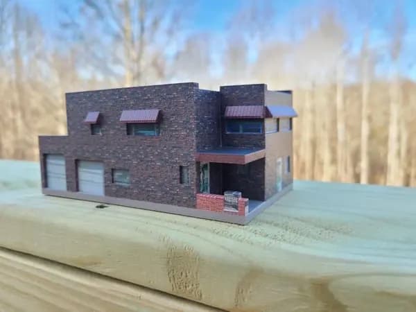 A 3D printed architectural model of a modern home on a timber base