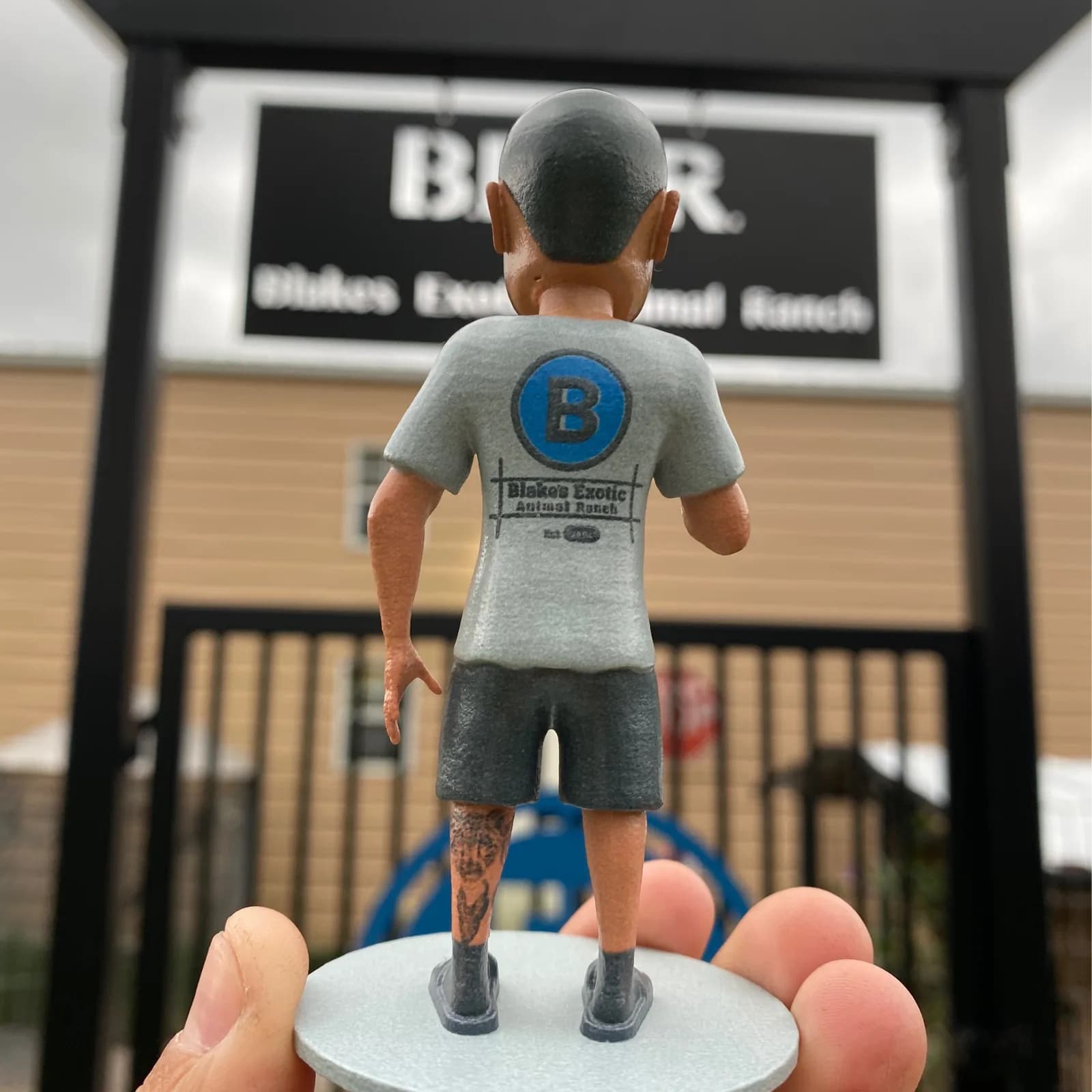 A hand holding a custom 3D printed figurine of a person made from photographs