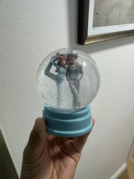 A custom snow globe with stylised 3D printed figures of a couple