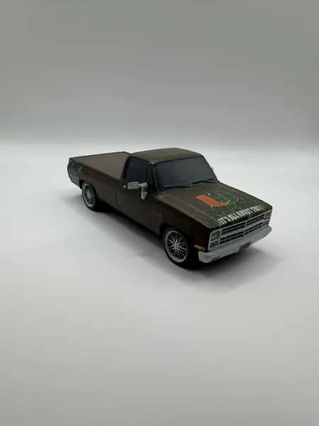 A 3D printed black pickup truck model photographed on seamless white