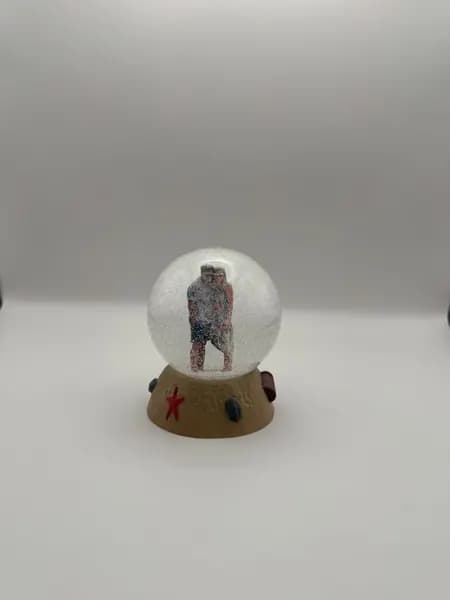 A custom 3D printed snow globe containing a couple on a hand-sculpted sand base with a starfish