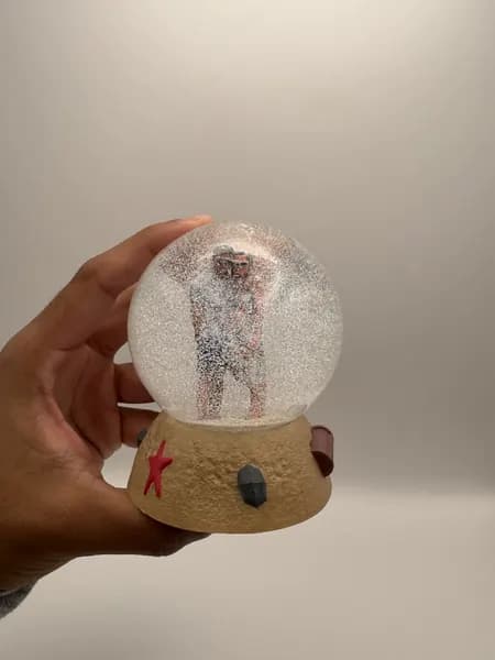 A custom 3D printed snow globe containing a couple on a hand-sculpted sand base with a starfish