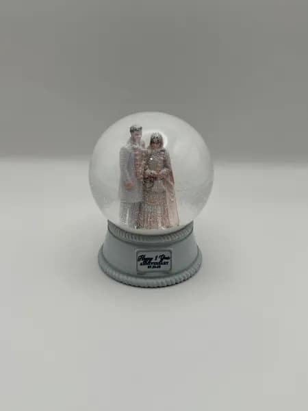 A custom 3D printed snow globe containing a couple in full Indian wedding dress