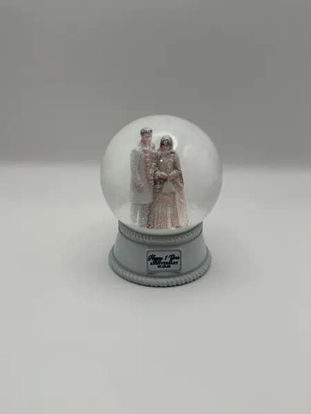 A custom 3D printed snow globe containing a couple in full Indian wedding dress