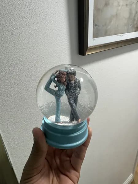 A custom 3D printed snow globe containing a stylised manga couple