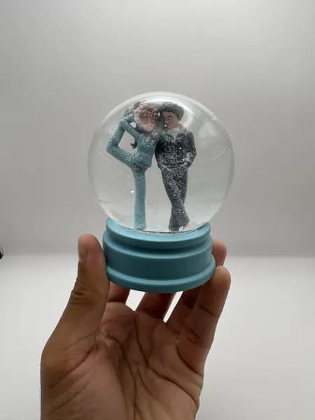 A custom 3D printed snow globe containing a stylised manga couple