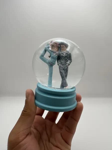 A custom 3D printed snow globe containing a stylised manga couple