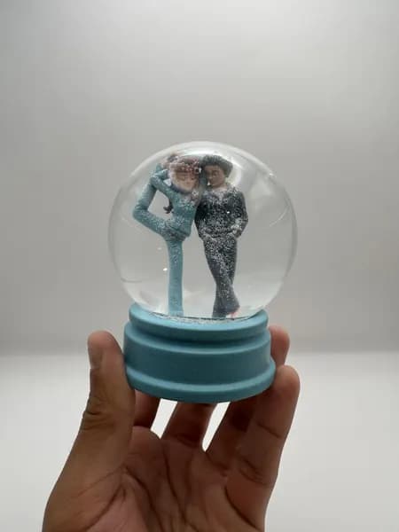 A custom 3D printed snow globe containing a stylised manga couple
