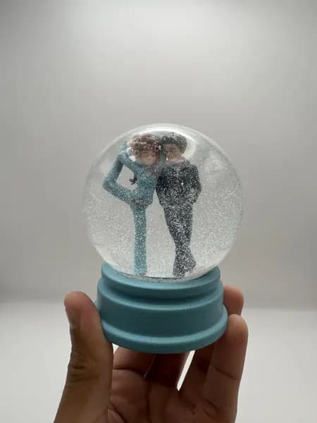 A custom 3D printed snow globe containing a stylised manga couple