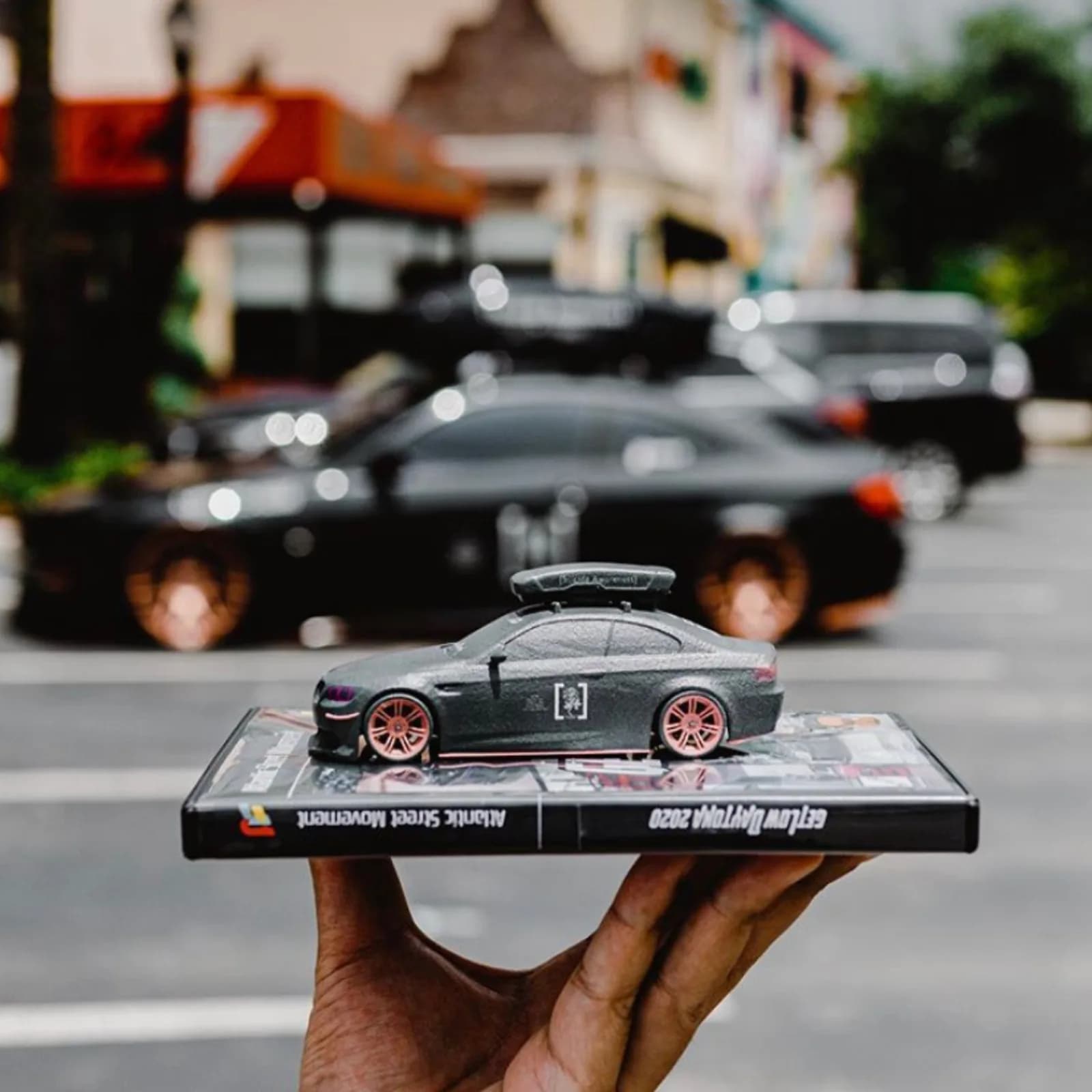 A black 3D printed sports car replica on a display plinth